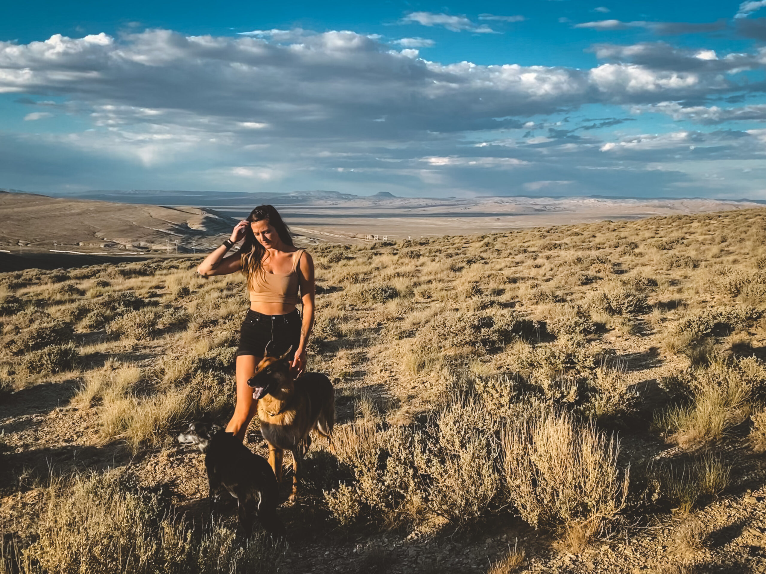 a girl and her two dogs on the plains of wyoming